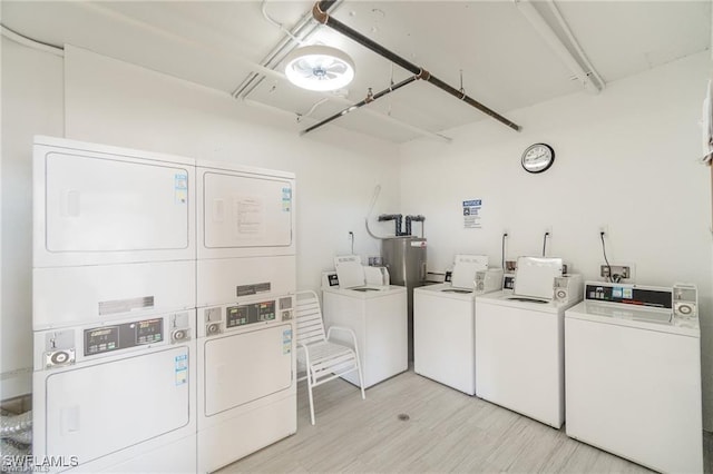 shared laundry area with water heater, stacked washer / dryer, independent washer and dryer, and light wood-style floors