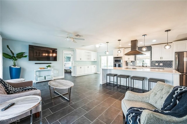 tiled living room featuring ceiling fan and sink