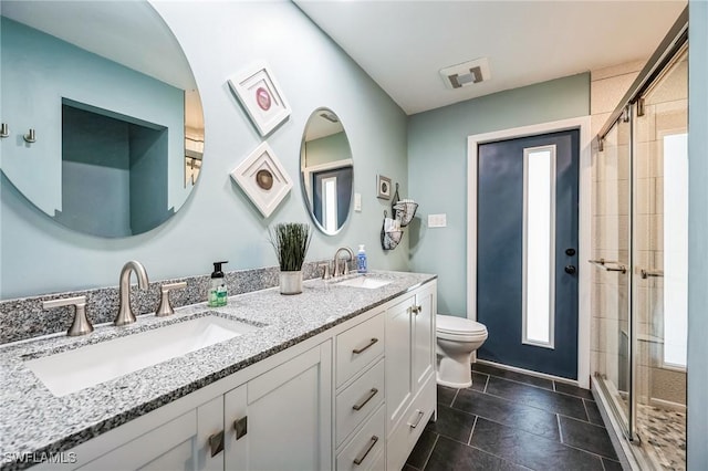 bathroom with toilet, vanity, and an enclosed shower