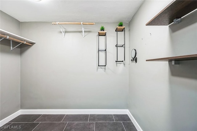 walk in closet featuring dark tile patterned flooring