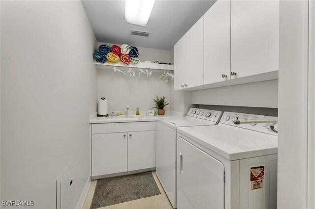 laundry room with sink, cabinets, and washer and dryer