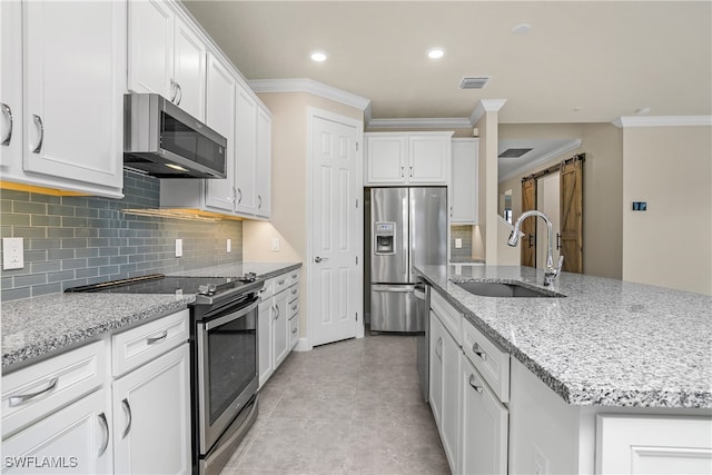 kitchen with stainless steel appliances, sink, a center island with sink, and white cabinets