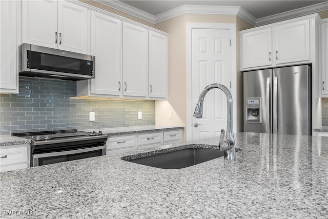 kitchen featuring appliances with stainless steel finishes, light stone countertops, and white cabinets