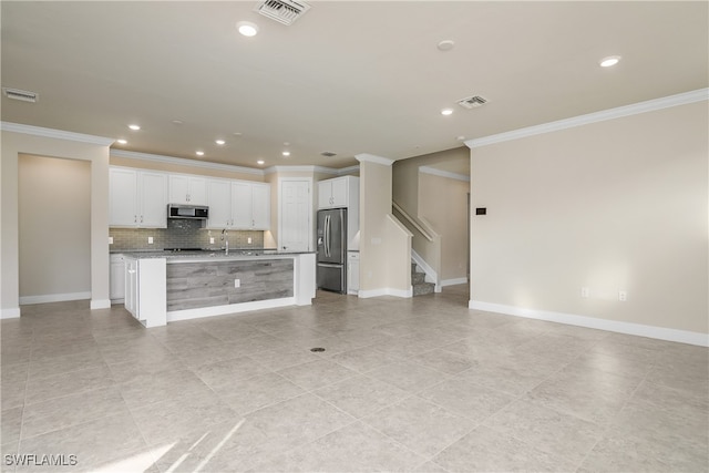 kitchen featuring white cabinetry, appliances with stainless steel finishes, an island with sink, and light stone counters