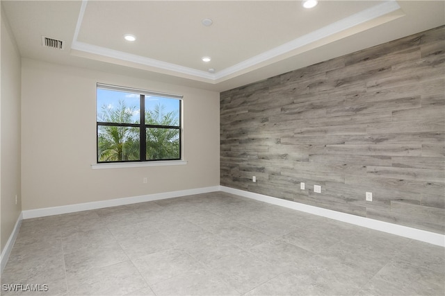 unfurnished room featuring a raised ceiling and ornamental molding