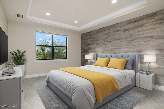 bedroom featuring a raised ceiling and wood walls