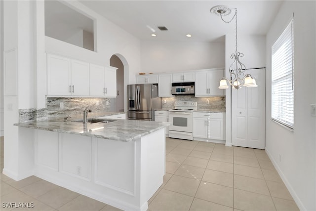 9234 Springview Loop, Estero, FL 33928 - kitchen with stainless steel appliances, a sink, light tile patterned flooring, backsplash, and a high ceiling