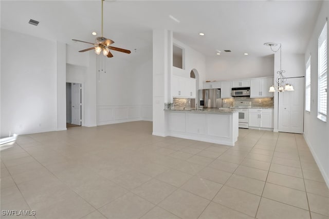 9234 Springview Loop, Estero, FL 33928 - unfurnished living room featuring a towering ceiling, ceiling fan, light tile patterned flooring, and recessed lighting