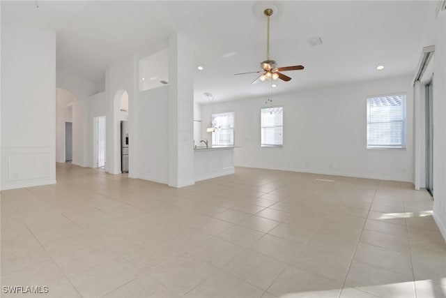 9234 Springview Loop, Estero, FL 33928 - unfurnished living room featuring a ceiling fan, arched walkways, a sink, light tile patterned floors, and recessed lighting