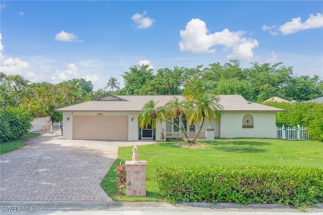 ranch-style home with a garage and a front lawn