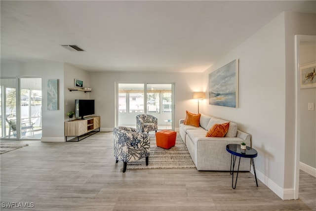 living room featuring a healthy amount of sunlight and light hardwood / wood-style floors