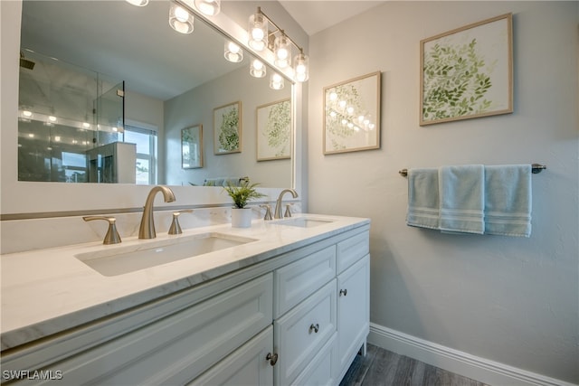 bathroom with a shower with shower door, hardwood / wood-style floors, and vanity