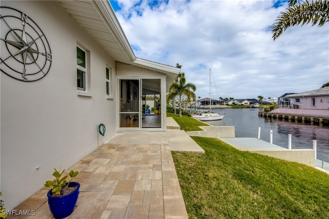 exterior space with a water view, a boat dock, and a patio area