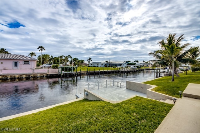 view of dock with a water view and a lawn