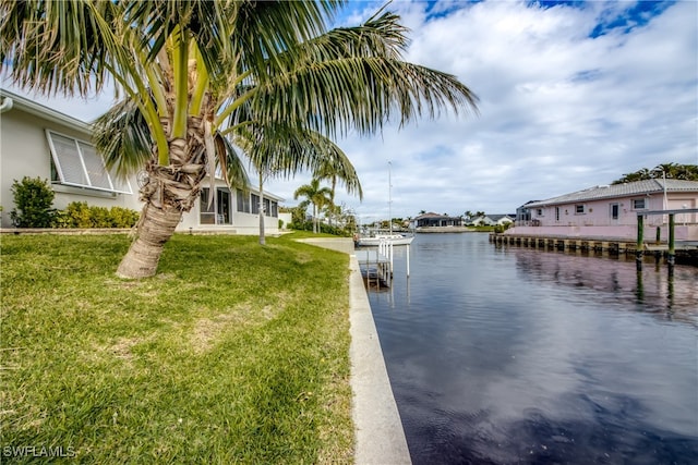 dock area featuring a lawn and a water view