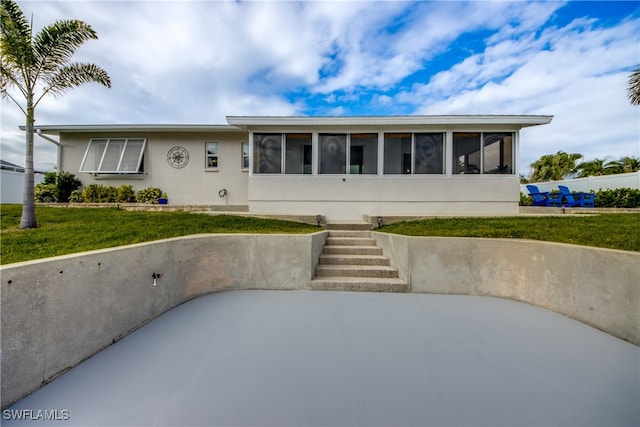 view of front of house featuring a front lawn and a sunroom