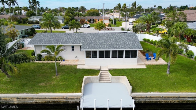 rear view of house featuring a lawn and a patio