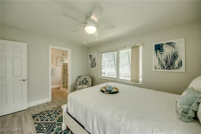 bedroom with ceiling fan, light wood-type flooring, and connected bathroom