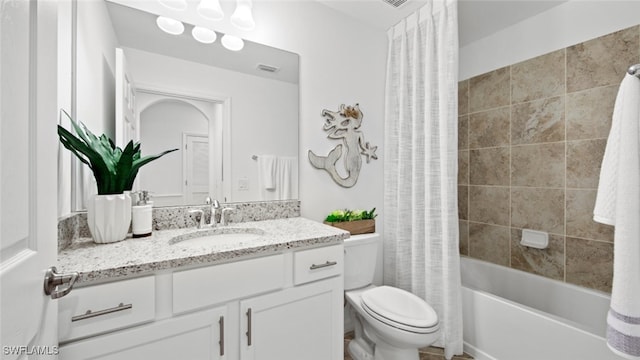 full bathroom featuring shower / bath combo with shower curtain, toilet, and vanity