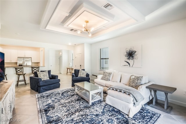 tiled living room with a notable chandelier and a raised ceiling