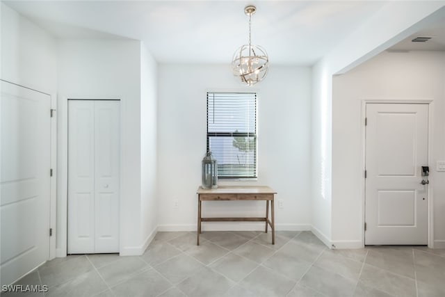 tiled entryway featuring an inviting chandelier