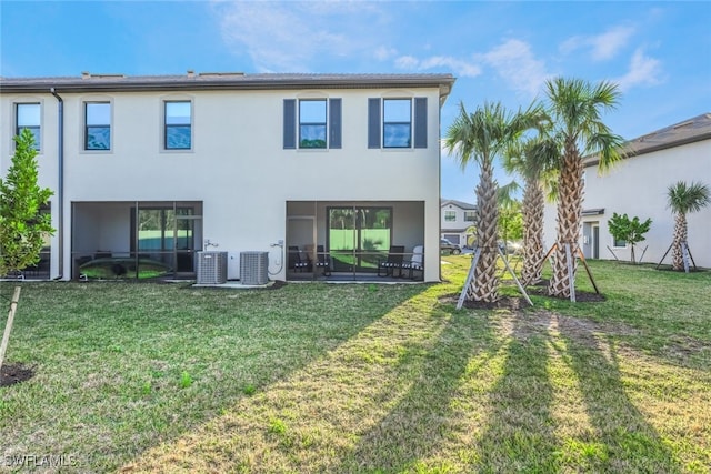 back of property with central air condition unit and a lawn