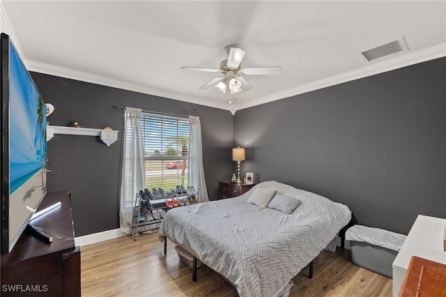 bedroom with ornamental molding, ceiling fan, and light hardwood / wood-style floors