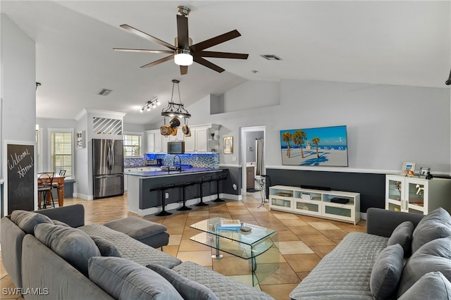 living room with sink, ceiling fan, vaulted ceiling, and light tile patterned floors