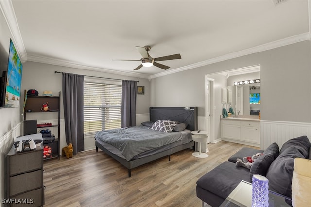 bedroom featuring ceiling fan, crown molding, hardwood / wood-style floors, and ensuite bath