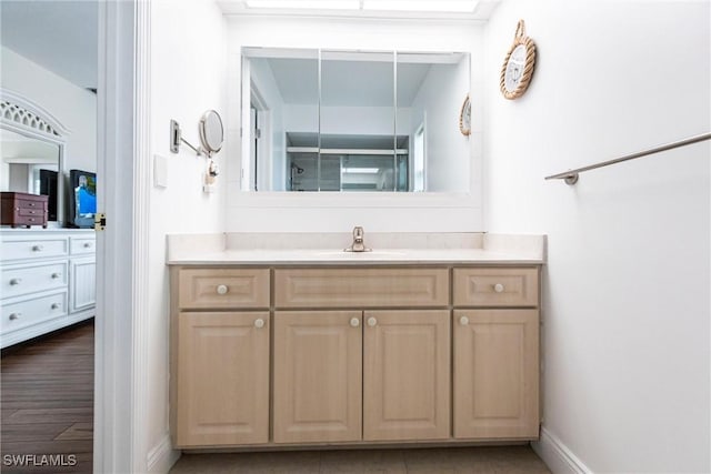 bathroom featuring a shower with shower door and vanity