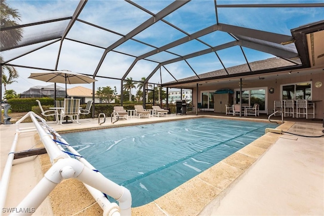 view of swimming pool featuring a patio and glass enclosure