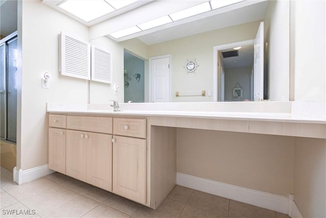 bathroom featuring tile patterned flooring, a skylight, and vanity