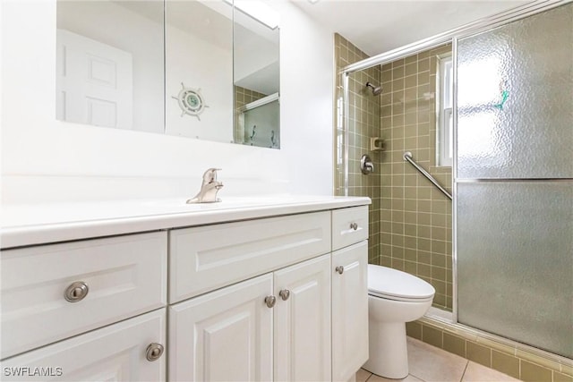 bathroom with vanity, toilet, tile patterned floors, and a shower with door