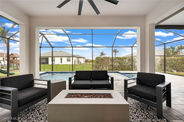 view of patio featuring a lanai, ceiling fan, and an outdoor living space with a fire pit