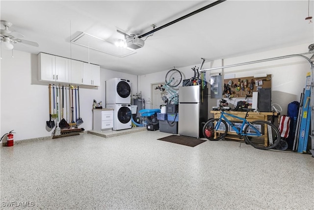 garage with ceiling fan, electric panel, stacked washer and clothes dryer, stainless steel fridge, and a garage door opener