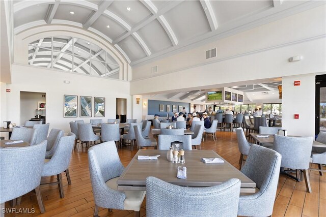 dining area featuring hardwood / wood-style floors and high vaulted ceiling