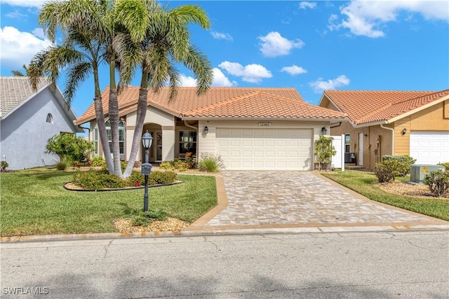 mediterranean / spanish-style home with a garage and a front yard