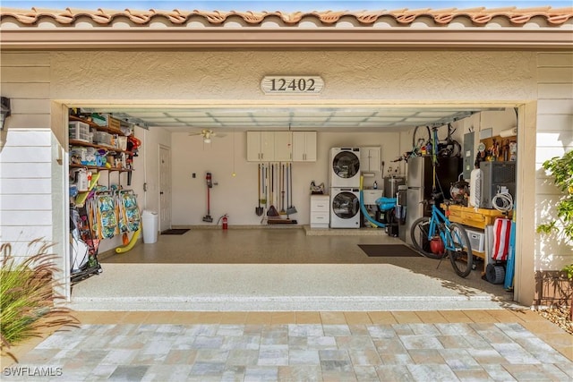 garage with stacked washing maching and dryer and electric panel