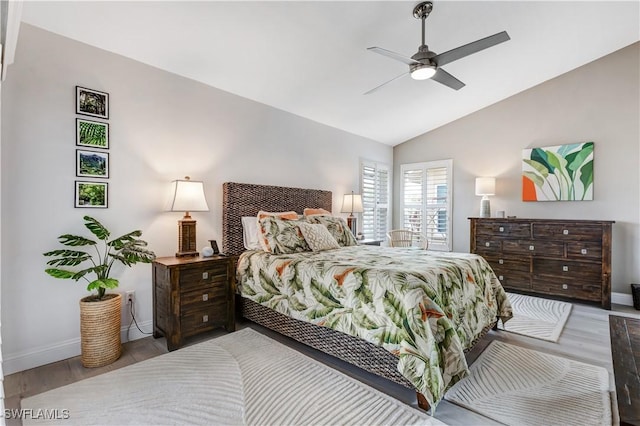 bedroom with ceiling fan, hardwood / wood-style flooring, and lofted ceiling