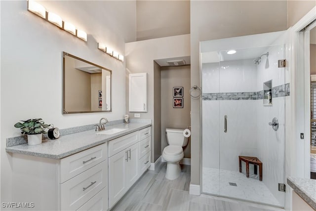 bathroom with an enclosed shower, vanity, and toilet