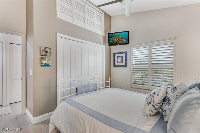 bedroom featuring light wood-type flooring, a closet, and ceiling fan