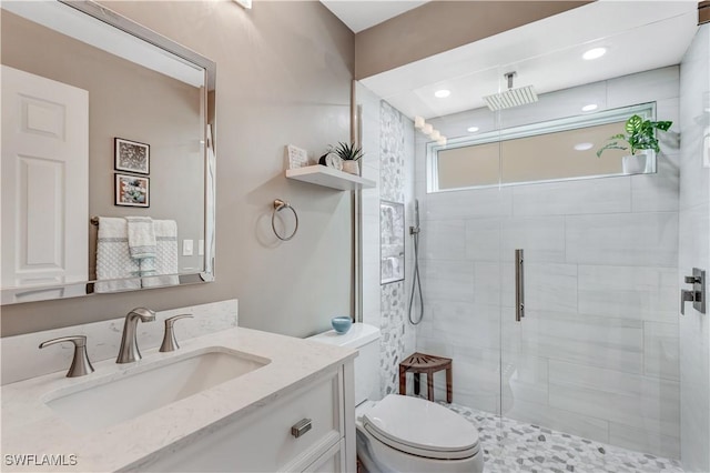 bathroom featuring vanity, toilet, and an enclosed shower