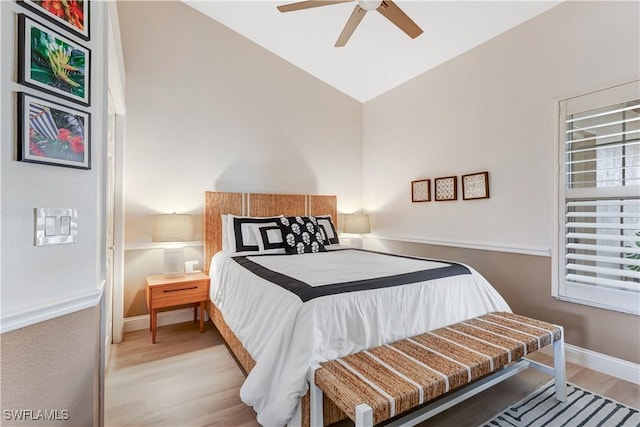 bedroom with ceiling fan, lofted ceiling, and light wood-type flooring