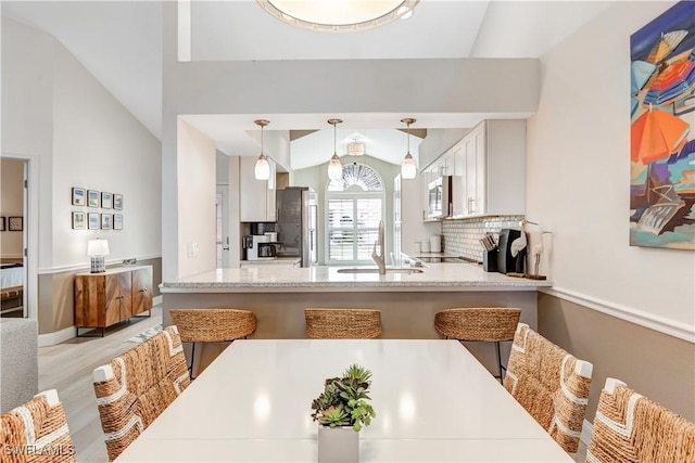 dining area with sink and lofted ceiling