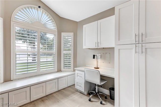 office space with vaulted ceiling and light wood-type flooring