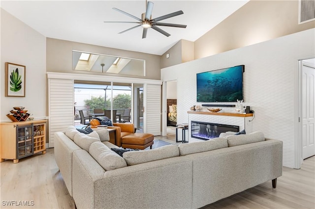 living room featuring ceiling fan, lofted ceiling, and light hardwood / wood-style flooring