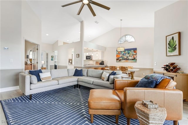 living room with ceiling fan, hardwood / wood-style floors, and high vaulted ceiling