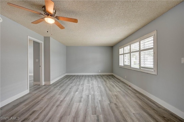 unfurnished room with ceiling fan, light hardwood / wood-style flooring, and a textured ceiling