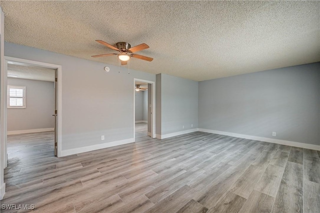 unfurnished room with ceiling fan, light hardwood / wood-style floors, and a textured ceiling