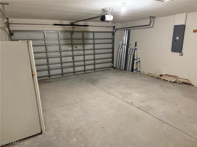 garage with electric panel, white fridge, and a garage door opener